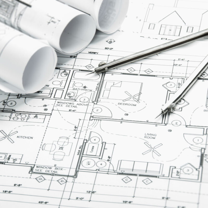 Architectural blueprints with drafting compass and rolled plans