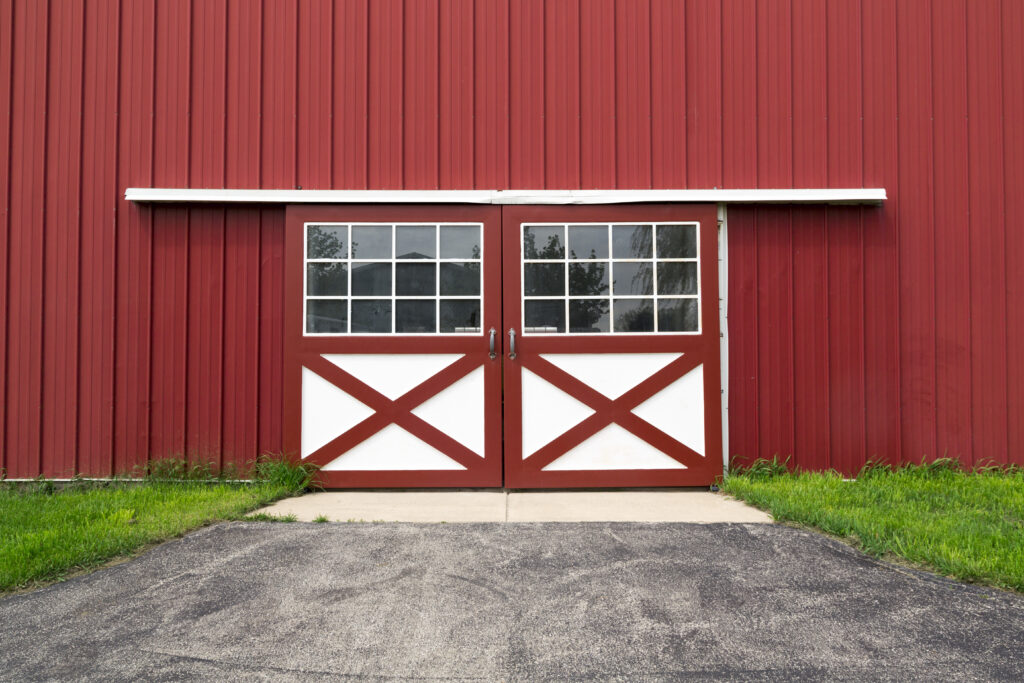 Red steel horse barn with double Dutch doors