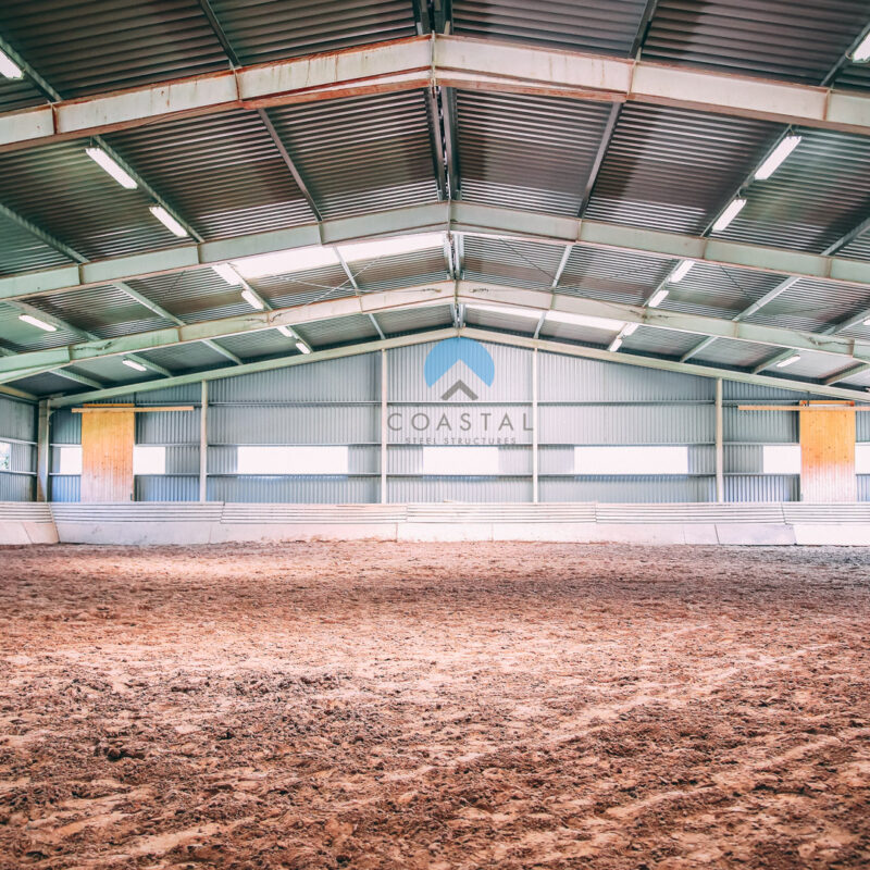 Covered riding arena inside a steel horse barn