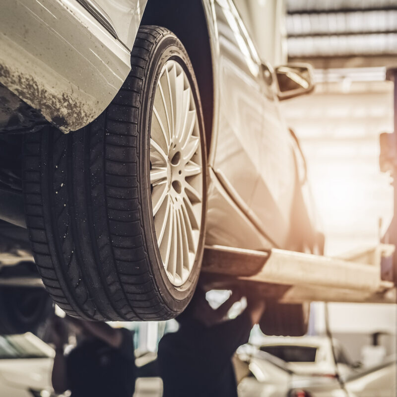 Car lifted in steel auto repair shop with hoist