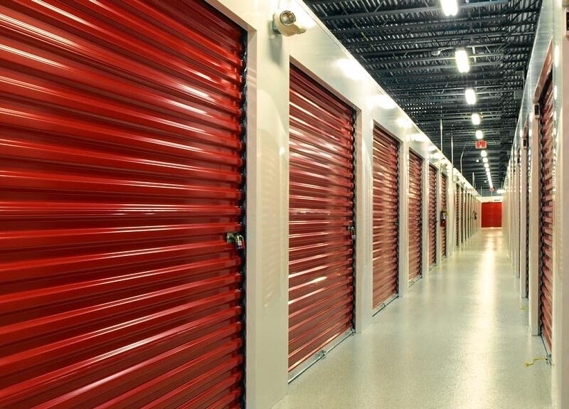 Interior corridor of commercial metal storage building with red unit doors