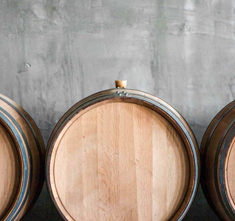 Three wooden wine barrels against concrete wall
