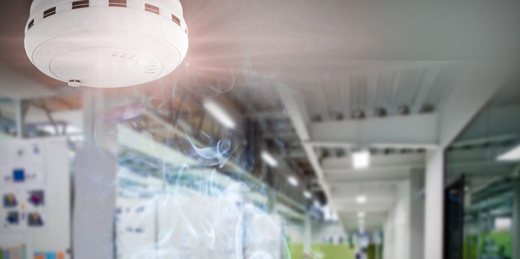 Indoor office with smoke detector in metal building ceiling