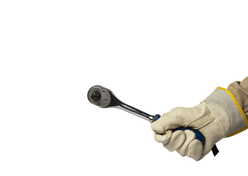 Gloved hand holding ratchet wrench on white background