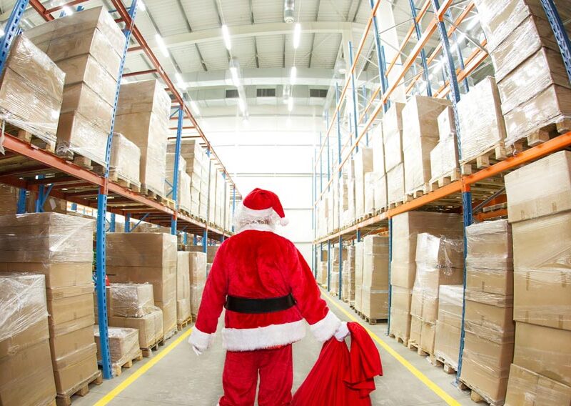 Santa walking through a steel warehouse storage building aisle