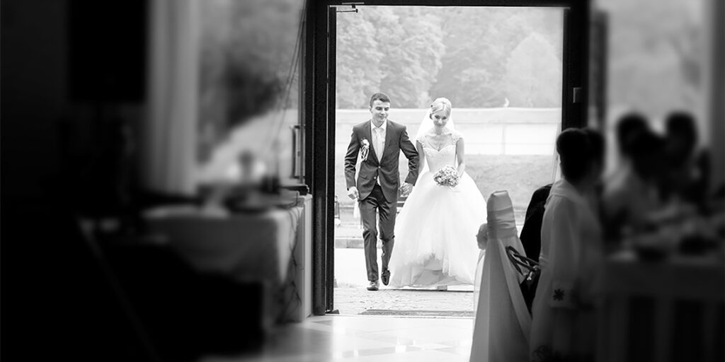 Wedding couple entering a steel building venue entrance
