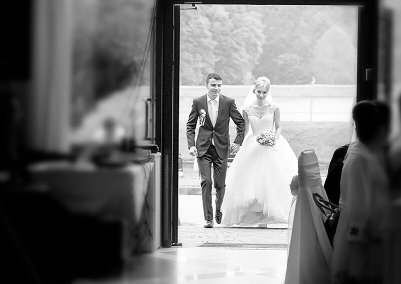 Wedding couple entering a steel building venue entrance