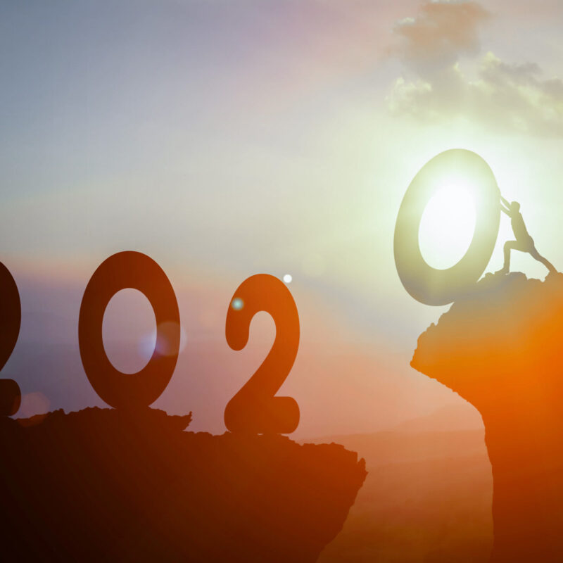 Silhouette of climber reaching summit with 2022 text overlay