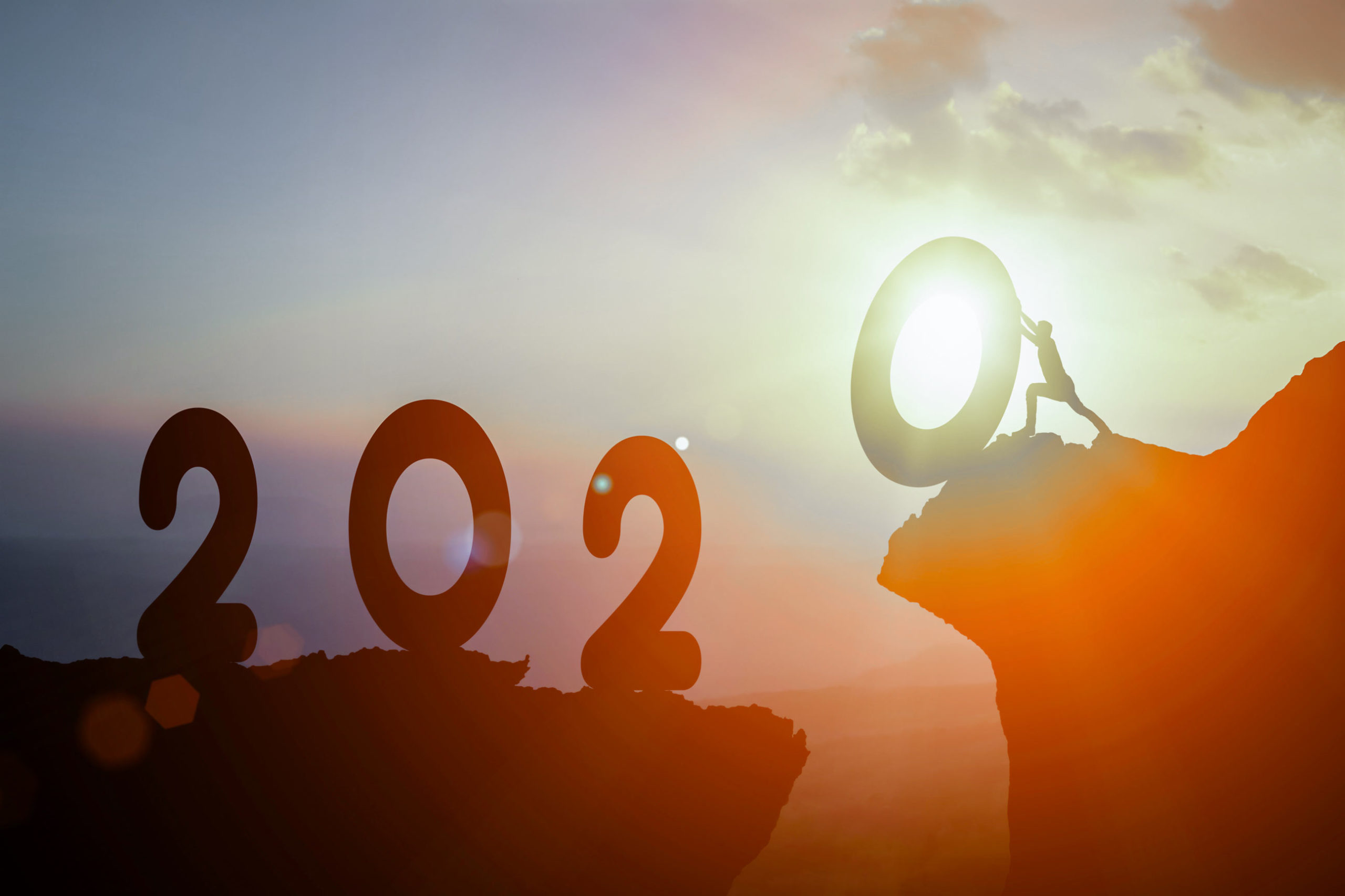 Silhouette of climber reaching summit with 2022 text overlay