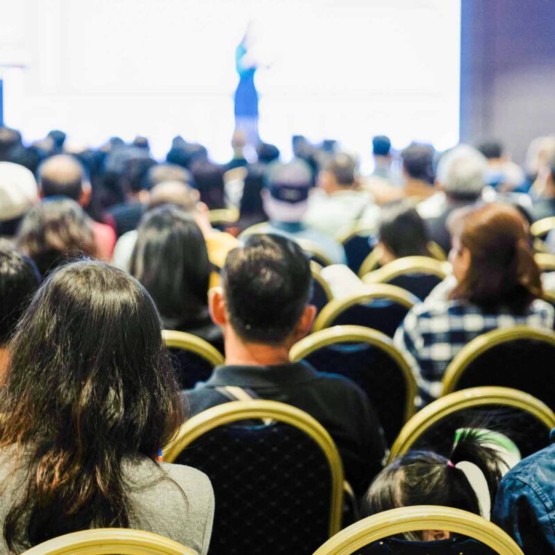 Audience seated at conference in metal building