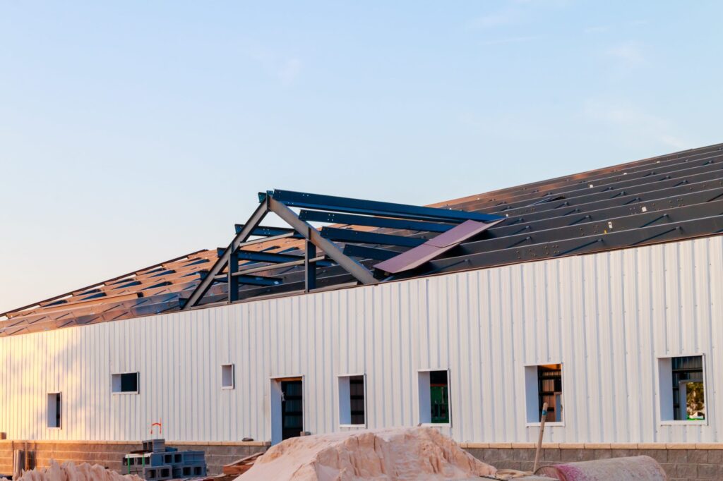 Steel building under construction with exposed roof trusses