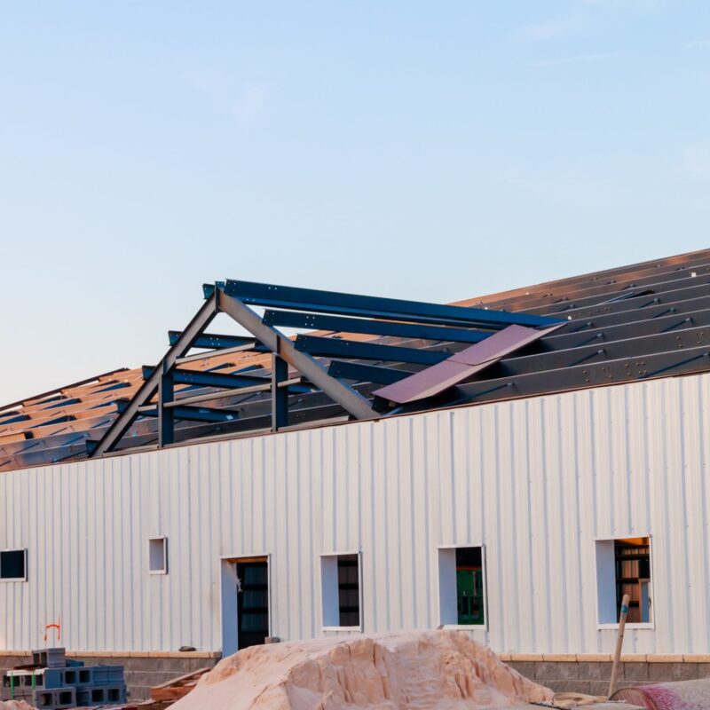 Steel building under construction with exposed roof trusses