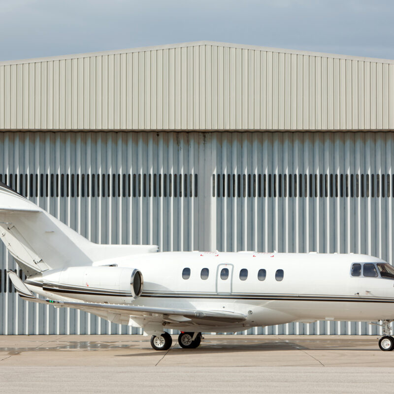 Aircraft hangar with private jet and corrugated metal building