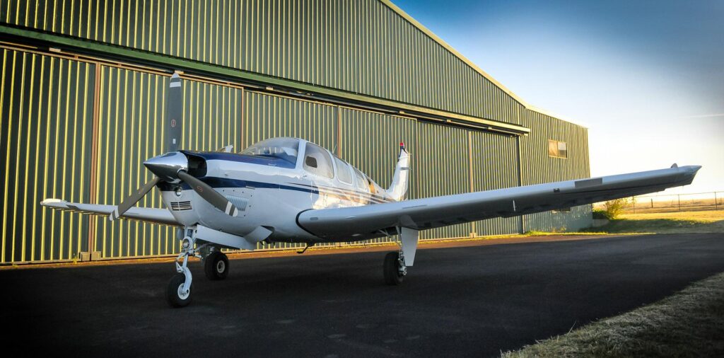 Aircraft parked outside a steel aircraft hangar