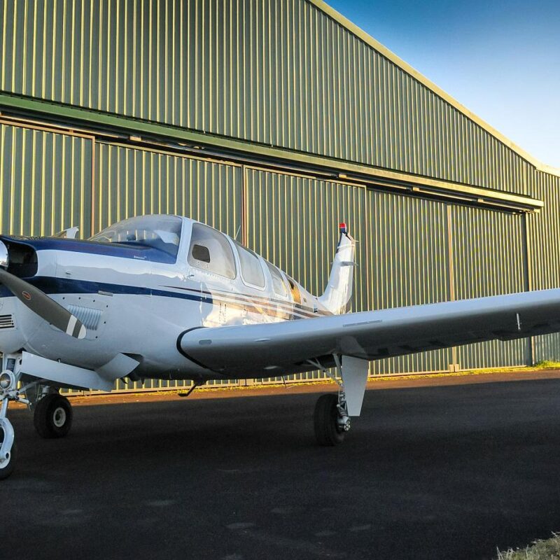 Aircraft parked outside a steel aircraft hangar