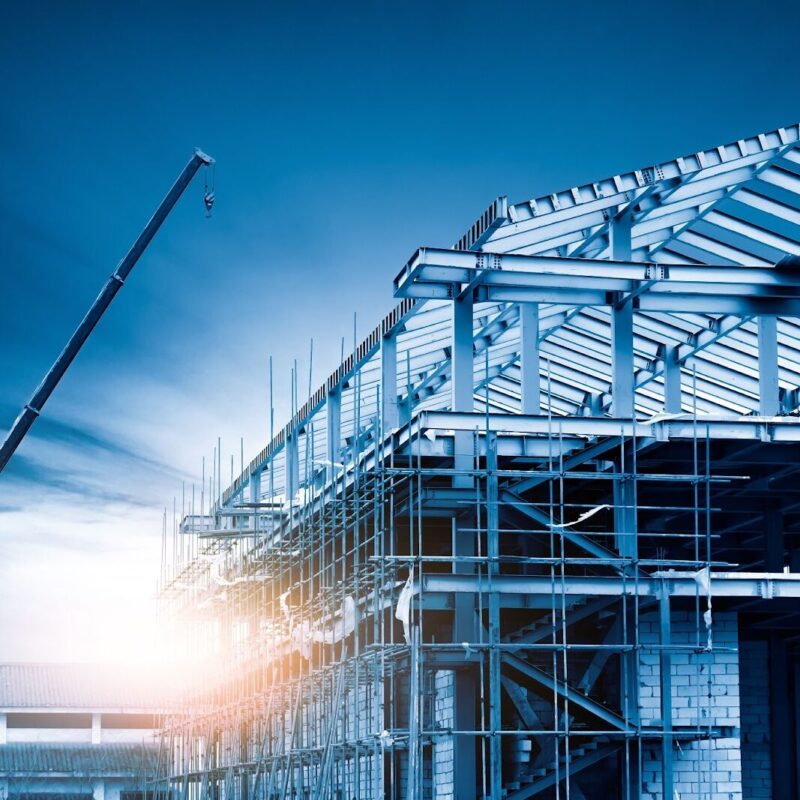 Steel building under construction with crane and scaffolding