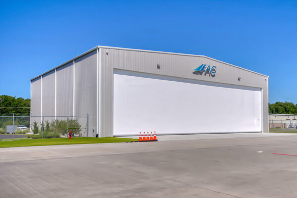 Steel aircraft hangar with large white door