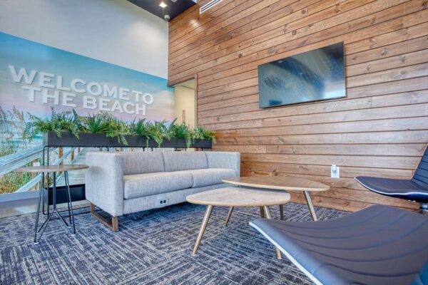 Modern beach-themed office lounge with wood wall and sofa