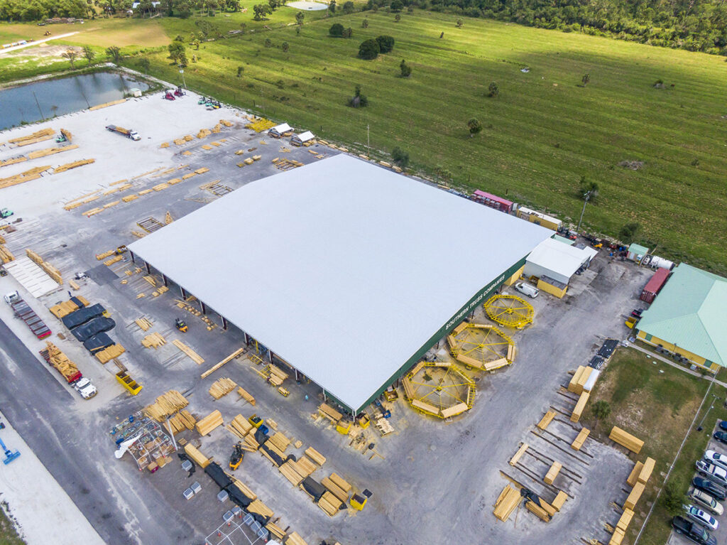 Aerial view of large steel building under construction on site