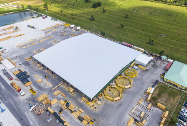 Aerial view of large steel building under construction on site