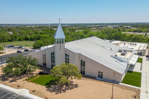 Steel church building with cross-topped steeple and metal roof