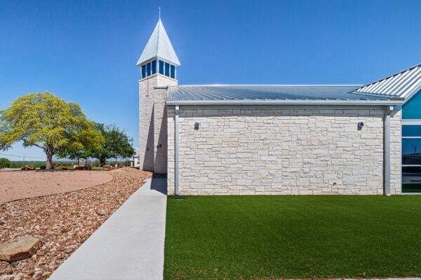 Stone-clad steel building with metal roof and tower