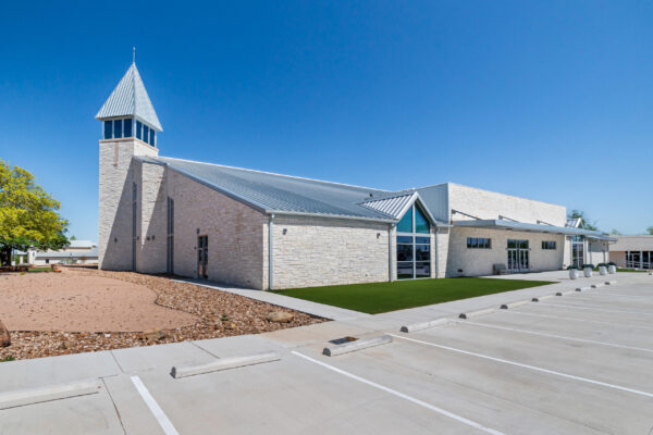 Stone-clad steel church building with metal roof and steeple