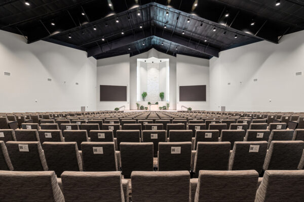 Interior of large steel church building with seating rows