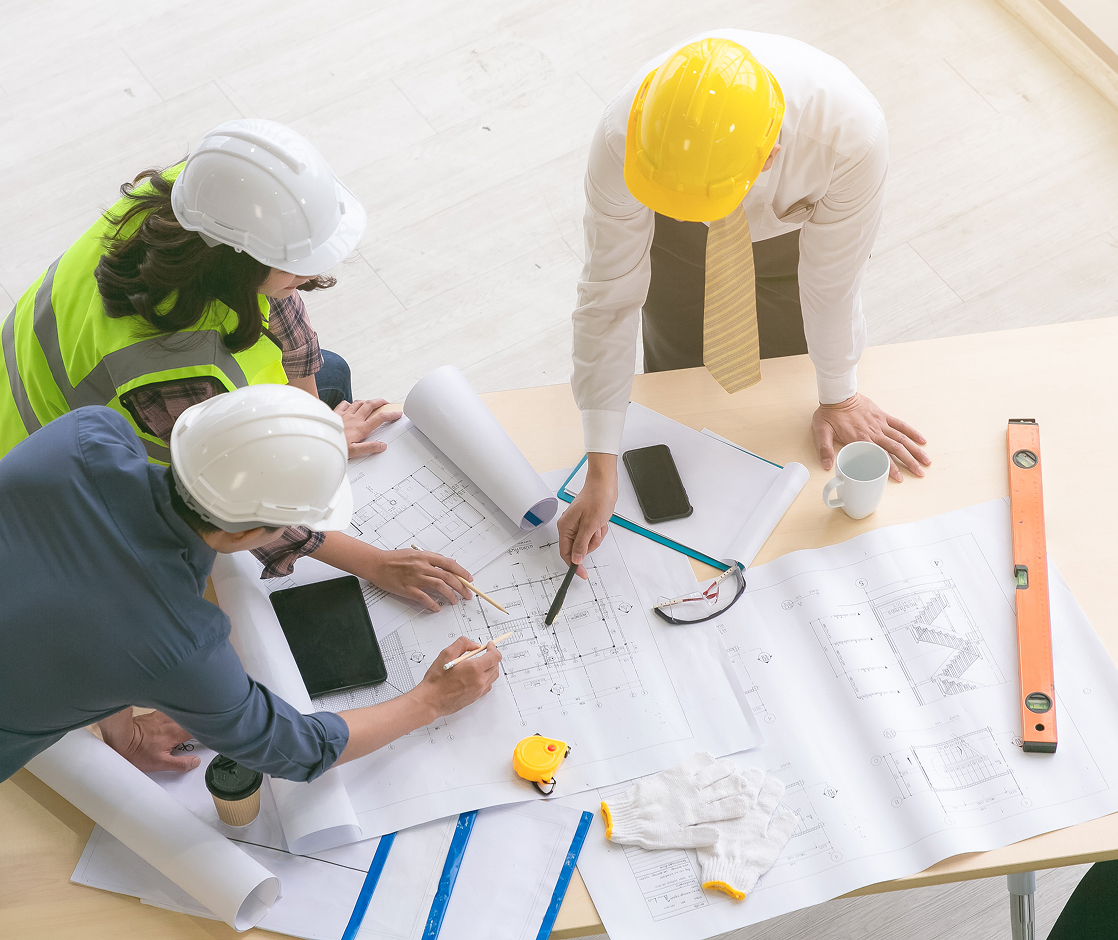 Engineers reviewing blueprints for a steel building project