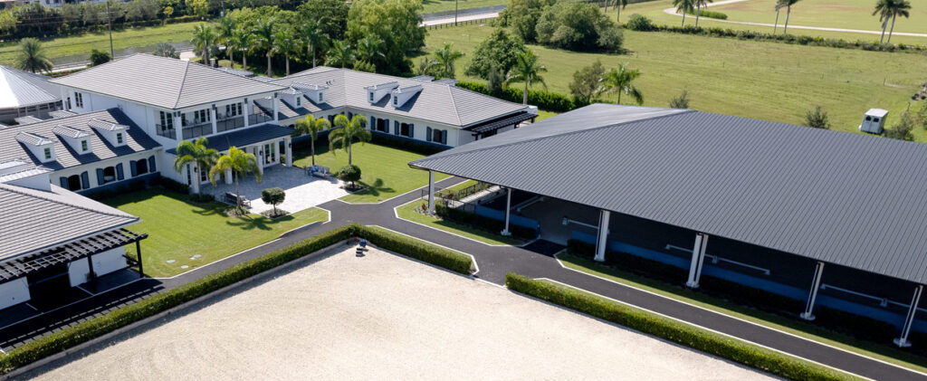 Aerial view of luxury estate with steel horse barn and arena