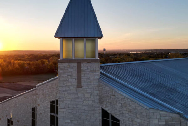 Stone church with metal roof at sunset