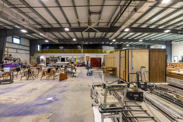 Interior of a large steel building workshop with metal framing and equipment