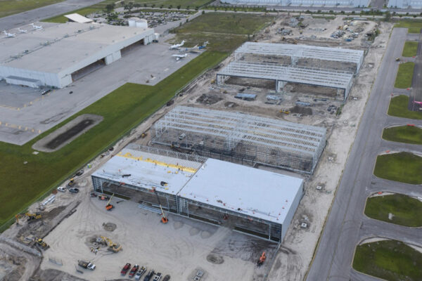 Aerial view of steel aircraft hangars under construction in airport complex