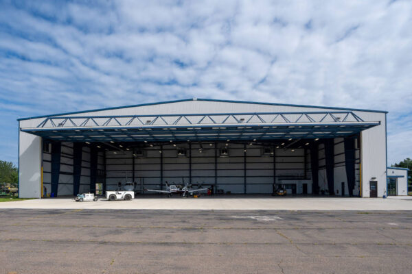 Aircraft hangar with open doors and small planes inside