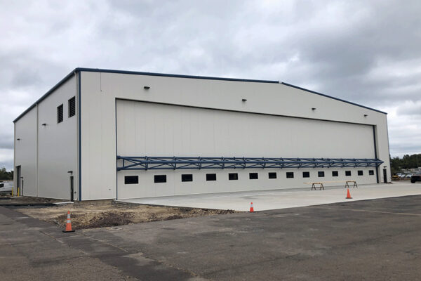 Pre-engineered steel aircraft hangar with large sliding door