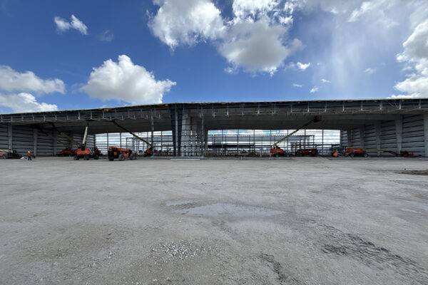 Steel aircraft hangar under construction with lift equipment