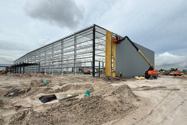 Steel building construction with lift equipment on site