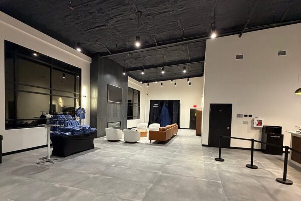 Open lobby gathering space inside a metal church building in Richardson, TX, with lounge seating and a fireplace wall