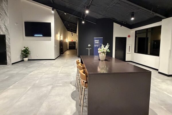 Lobby welcome area inside Zion Church with a high-top table and open ceiling